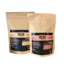 Das Bild zeigt zwei Standbodenbeutel mit der Aufschrift 70/30 Arabica. Verpackt in wiederverschließbaren Kraftpapier-Beuteln mit Ventil.